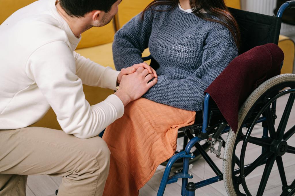 woman in wheelchair with companion holding hand